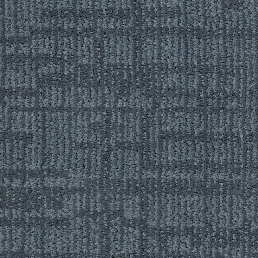 Close-up of Lineage Pet Friendly Carpet in blue-gray, made with EnVisionSD yarn. Features a subtle geometric pattern of intersecting lines and squares, with soft looped fibers for a modern, textured look.