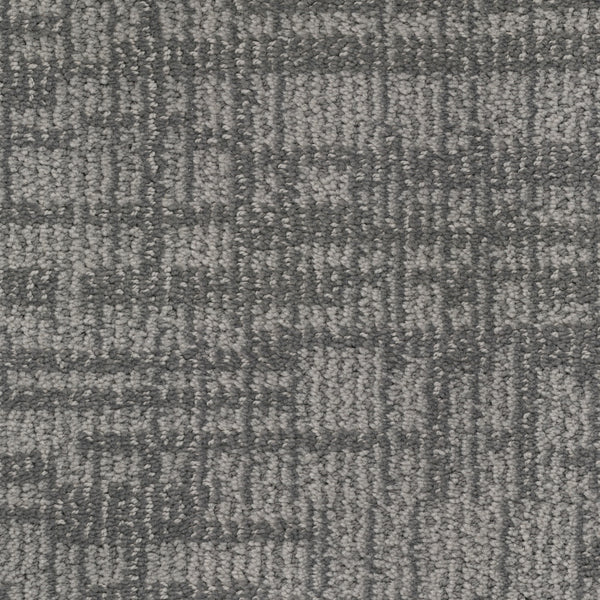 Close-up view of Lineage Pet Friendly Carpet: a gray textured surface with a subtle, irregular grid-like pattern. Made from solution dyed EnVisionSD yarn, it offers a soft feel and modern, neutral tones—ideal for contemporary spaces.