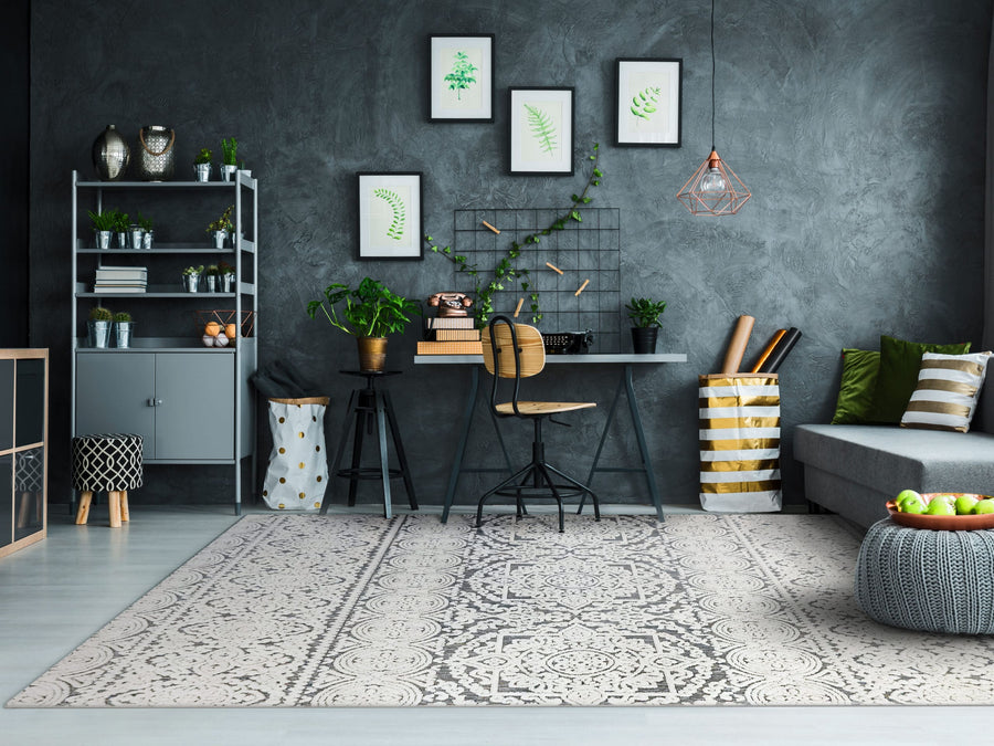 Modern living room with the Lotus 8146 Area Rug featuring a high-low texture, gray walls, desk and chair, potted plants, framed botanical prints, a décor shelf, and a sectional sofa with striped cushions.