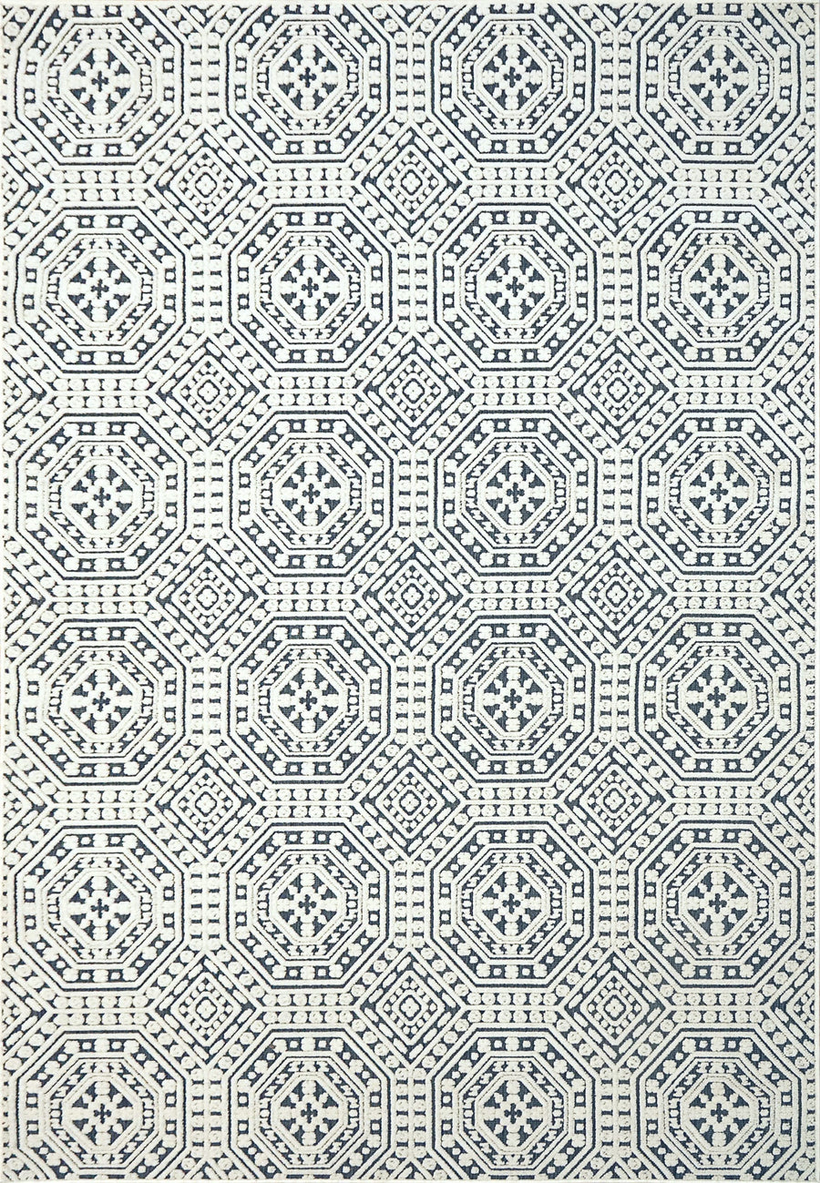 The Lotus 8149 Area Rug showcases a geometric pattern with navy octagons and diamonds on an off-white background, featuring a high-low texture for depth and a symmetrical, contemporary design.