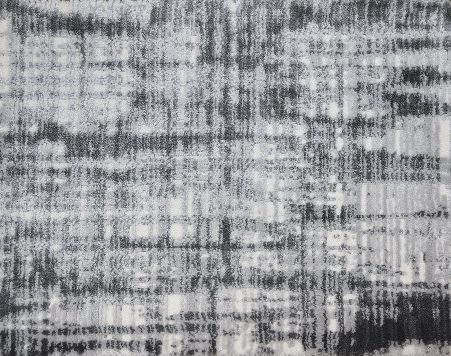 A close-up of a textured surface with an abstract, plaid-like pattern in gray, black, and white captures the soft, fuzzy look of the Lulubella On Trend Carpet.