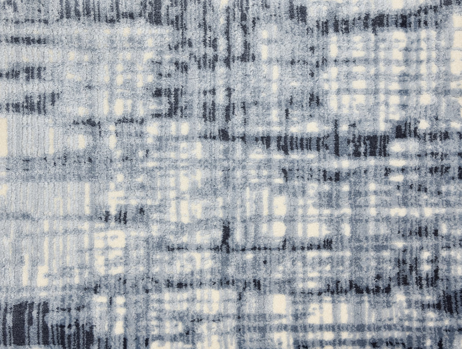 The Lulubella On Trend Carpet features a soft, textured design with intersecting dark blue and white lines, creating a blurred grid pattern reminiscent of a woven rug or sketchy crosshatched drawing.