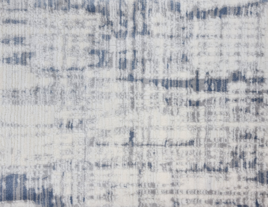 The Lulubella On Trend Carpet features abstract patterns in cream, grey, and blue with irregular lines and shapes, offering a textured, modern distressed look perfect for contemporary spaces.