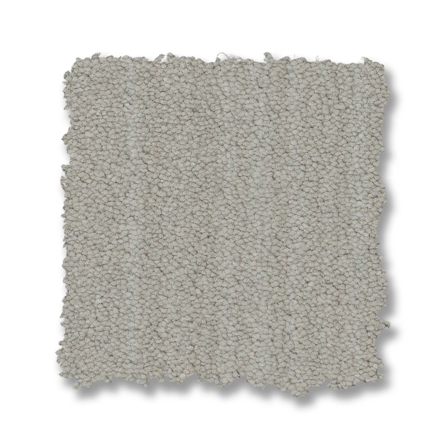A square swatch of Magnifique On Trend Carpet in light gray with a looped pile texture is shown on a white background, featuring slightly uneven edges that showcase the stylish look and timeless appeal of this carpet.