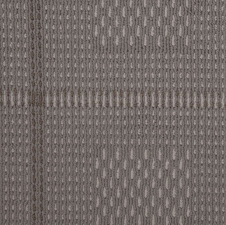 Close-up of the Bombay Vibration Berber Carpet showcasing its textured gray fabric with a subtle woven sisal pattern, small ovals, and intersecting dark and light lines in a grid design—an elegant Masland creation.