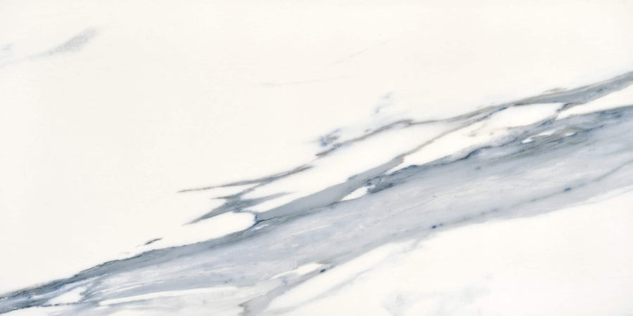 The Milan 24x48 Polished Porcelain Tile features a white marble look with subtle gray and blue diagonal veining, capturing the smooth, elegant pattern of natural stone in a refined porcelain surface.