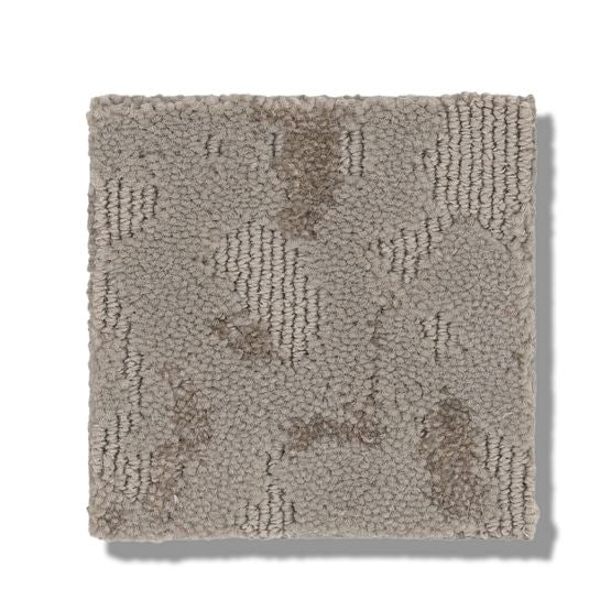 A square sample of Ming On Trend Carpet in a light grayish-tan color with subtle, irregular darker patches and a soft looped pile is displayed on a white background.