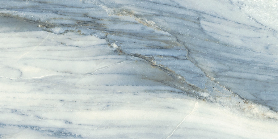 A close-up of Monte Carlo 12x24 Matte Porcelain Tile reveals a smooth surface with blue, gray, and white swirls and veins, blending marble-inspired luxury and natural beauty in an abstract design.