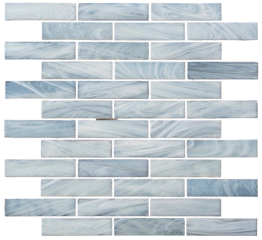 The New England Brick Glass Tile features blue and white handmade mosaic pieces in a staggered brick pattern with unique marbled designs, perfect for bringing a calming touch to bathroom showers or kitchen backsplashes.