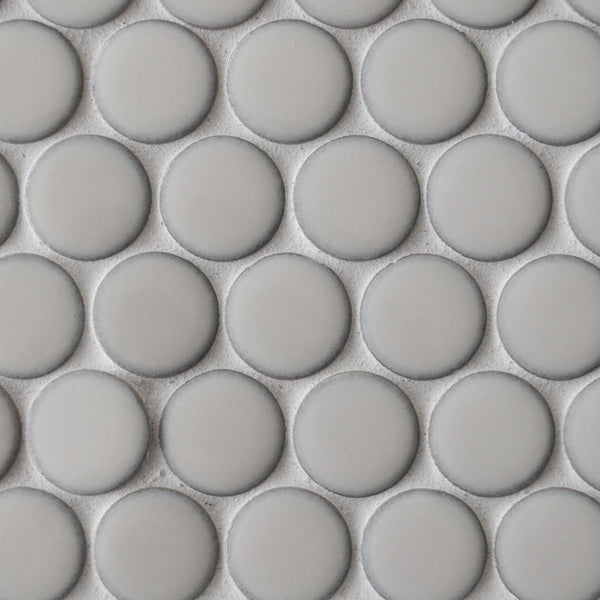 Close-up of New Form Penny Round Mosaic Tile—a modern tile with uniform, light gray matte circles and thin grout lines. Its geometric, grid-like pattern is ideal for contemporary backsplashes.
