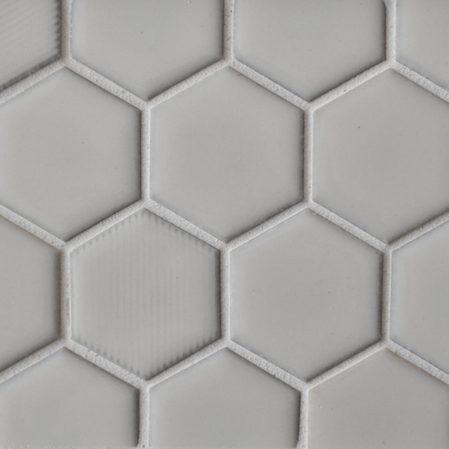 Close-up of New Form Hexagon Mosaic Tile in light gray, featuring a honeycomb geometric pattern with each tile outlined by textured grout—ideal for adding a stylish touch to backsplashes or shower walls.