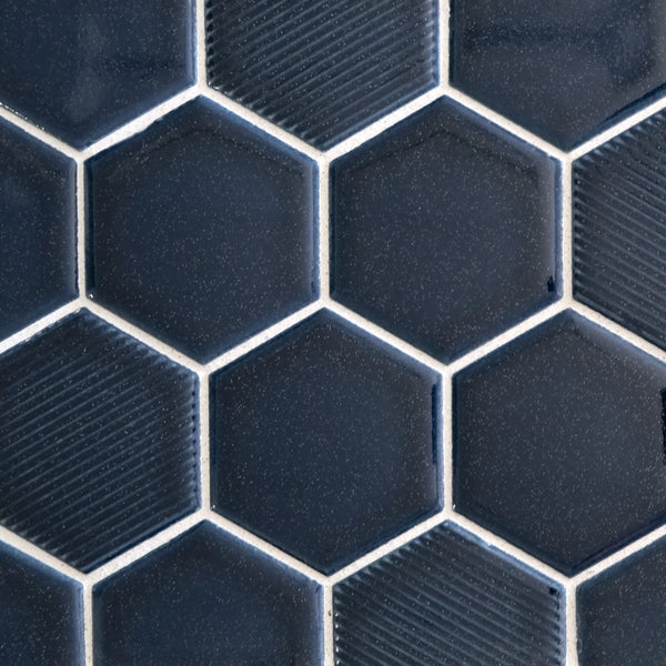 Close-up of New Form Hexagon Mosaic Tile in dark blue, featuring subtle texture variations and a honeycomb pattern with thin white grout—ideal for creating a striking backsplash or shower wall.