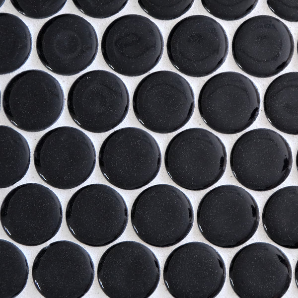 A close-up of New Form Penny Round Mosaic Tile shows glossy, round black tiles with white grout lines—ideal for creating a stylish backsplash or shower wall.