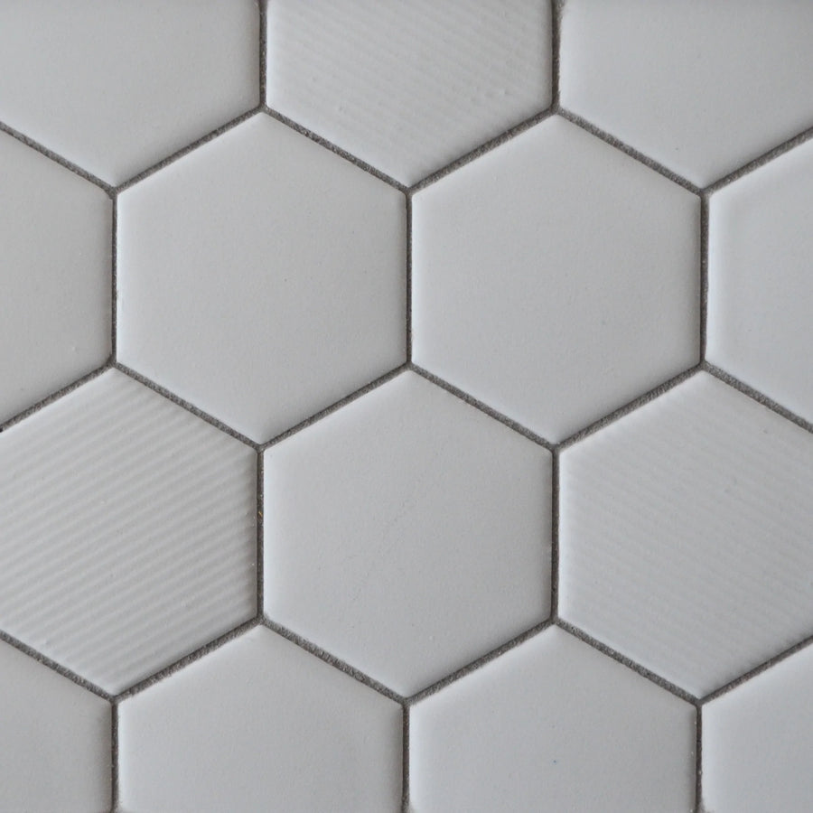 Close-up of New Form Hexagon Mosaic Tile: white hexagonal tiles in a honeycomb pattern with subtle texture variations and visible grout—ideal for adding style to shower walls or backsplashes.