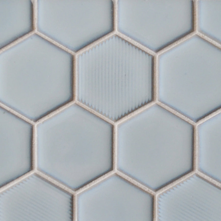 Close-up of New Form Hexagon Mosaic Tile in light blue, featuring a subtle ridged texture and honeycomb pattern with thin beige grout—perfect for a stylish shower wall or modern backsplash.