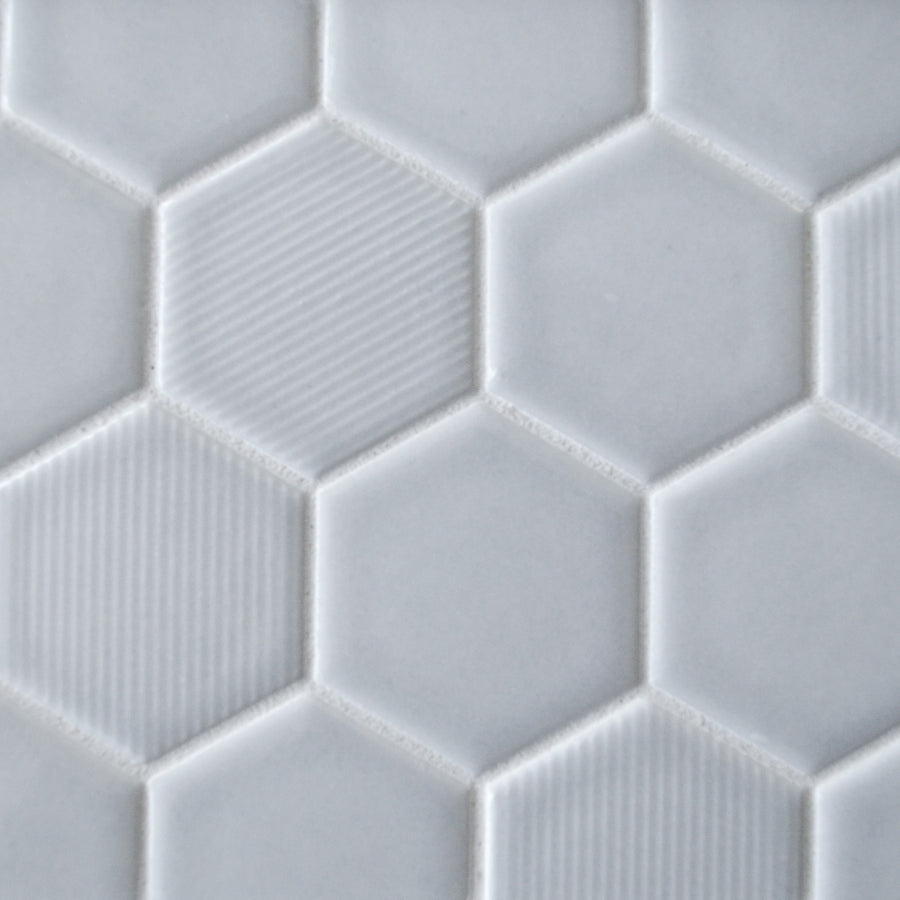 Close-up of New Form Hexagon Mosaic Tile in white, featuring a mix of smooth and subtly grooved surfaces. This geometric, honeycomb-inspired design is ideal for adding a stylish touch to backsplashes or shower walls.