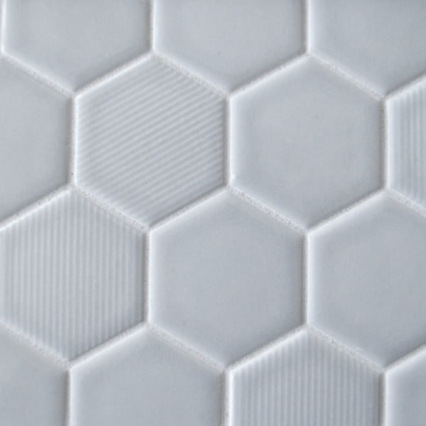 Close-up of New Form Hexagon Mosaic Tile in white, featuring a mix of smooth and subtly grooved surfaces. This geometric, honeycomb-inspired design is ideal for adding a stylish touch to backsplashes or shower walls.