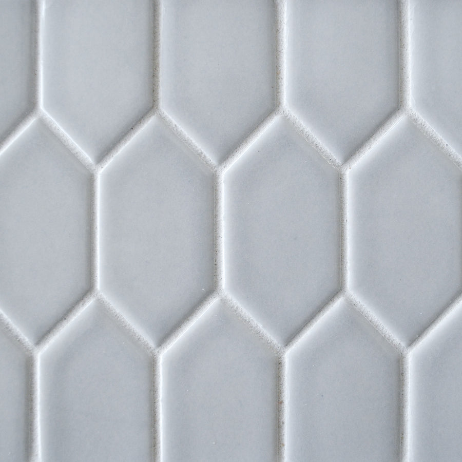 Close-up of New Form Picket Mosaic Tile, featuring a white surface with a repeating hexagonal pattern, slightly raised edges, and a matte finish—ideal for adding a modern touch to backsplashes or shower walls.