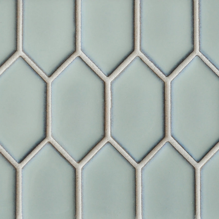 A close-up of New Form Picket Mosaic Tile in light blue, featuring a repeating elongated hexagonal pattern outlined in white grout—ideal for a stylish backsplash or shower wall.