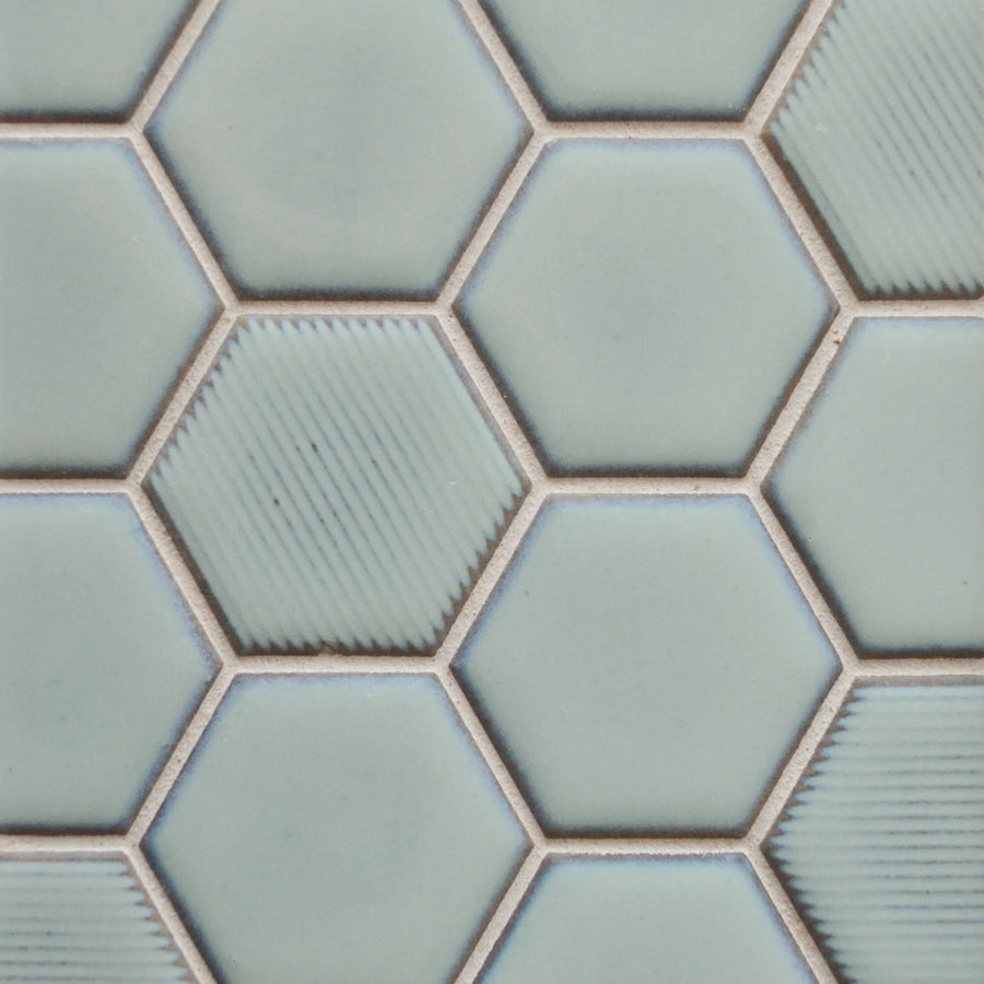Close-up of New Form Hexagon Mosaic Tile in light blue, featuring hexagonal shapes with some diagonal textured lines and light beige grout—perfect for a stylish shower wall or backsplash.