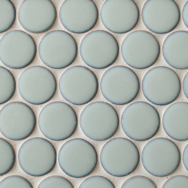 A close-up of New Form Penny Round Mosaic Tile in light blue, featuring round tiles arranged in a grid with white grout—ideal for a stylish shower wall or backsplash.