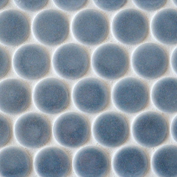 Close-up of New Form Penny Round Mosaic Tile: white surface with evenly spaced, round, blue-gray tiles in a grid pattern—perfect for a modern shower wall or backsplash.