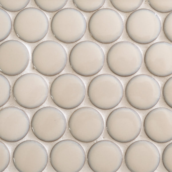 Close-up of New Form Penny Round Mosaic Tile: beige, glossy, round tiles set in a grid with light grout—an elegant pick for shower walls or backsplashes.