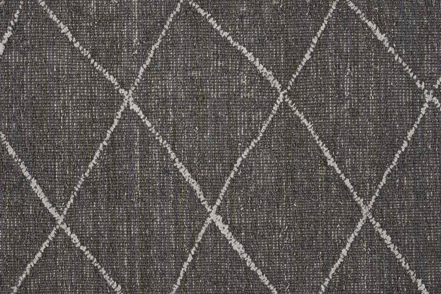 The Old World Trellis On Trend Wool Carpet features a dark gray textured fabric with large white diamond shapes created by intersecting diagonal lines, evoking the look of a vintage wool trellis rug.