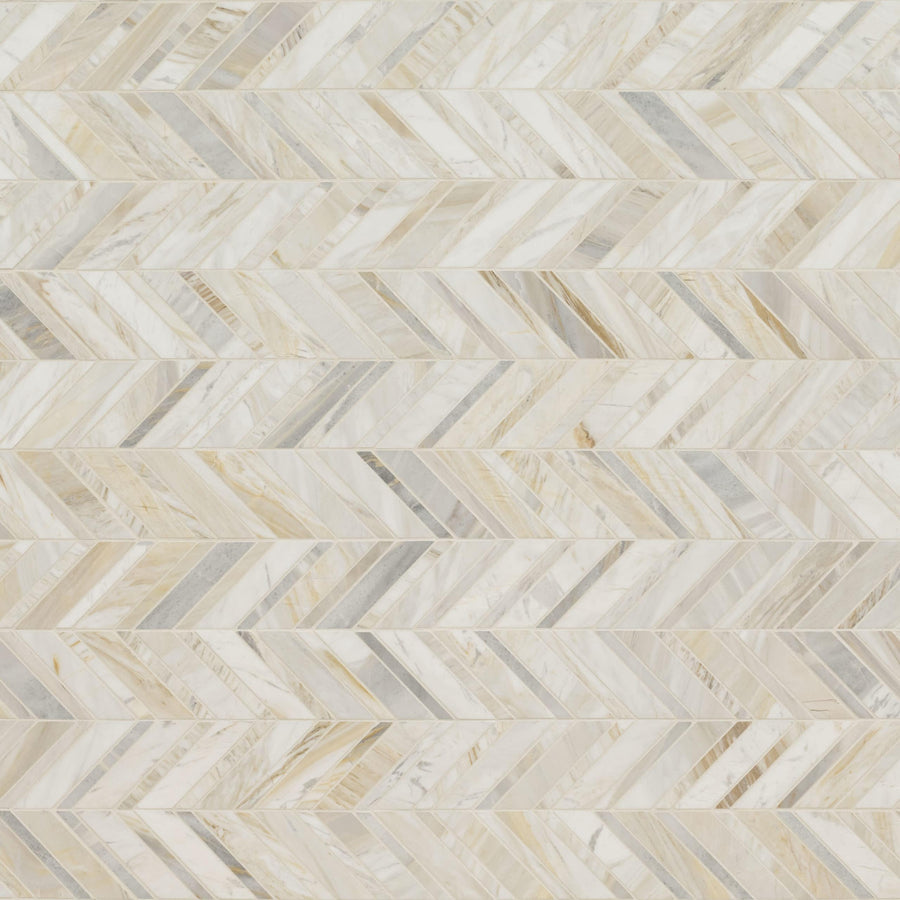 A close-up of Olympia Sandalwood Chevron Marble Mosaic shows a herringbone-patterned surface in cream, white, and light gray marble tiles with a glossy finish that reflects light.