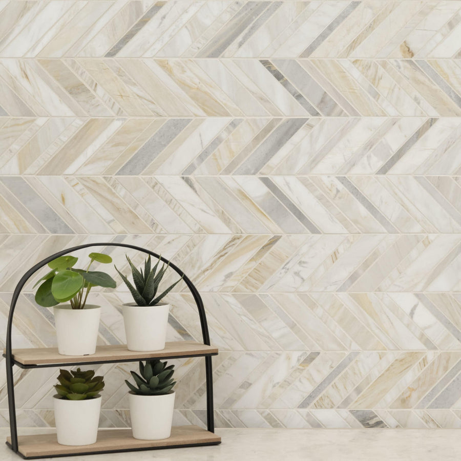 Four small potted plants rest on a two-tier wooden shelf with a black frame, set against a wall clad in Olympia Sandalwood Chevron Marble Mosaic, creating a modern and stylish accent.