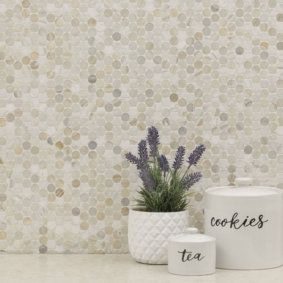 A white countertop with a potted lavender plant and two white containers labeled tea and cookies sits in front of an Olympia Sandalwood Penny Round Marble Mosaic tile backsplash.