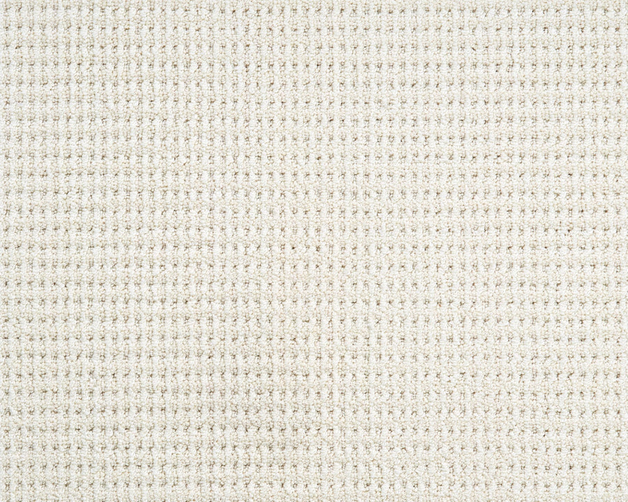 Close-up of the Bandala Jazzed Berber Carpet, showcasing its textured off-white surface with a grid pattern of small, evenly spaced squares and a soft, woven appearance.
