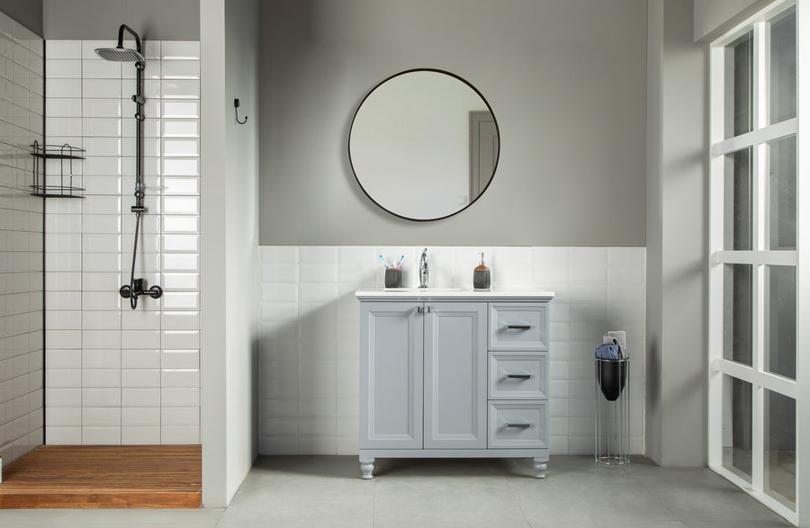 Modern bathroom with a walk-in shower on the left and the Isabel 36" Vanity with solid wood drawers and a round mirror at center. A waste bin by the large window on the right completes this clean, minimalistic space.