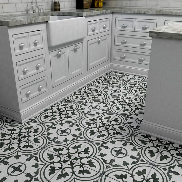 A kitchen corner with white cabinets, marble countertops, a farmhouse sink, and Arte 9 3/4 x 9 3/4 Patterned Tile on the floor and walls featuring bold black-and-white floral geometric circular designs.