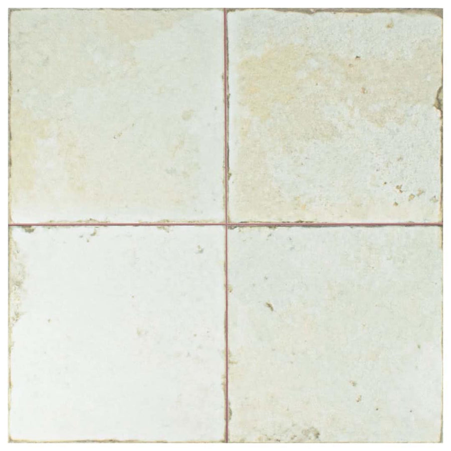 The Kings Manhattan 17 3/4 x 17 3/4 patterned tile features four square, light beige tiles with subtle staining and uneven edges, separated by thin reddish grout lines—perfect for adding vintage industrial style to floors or walls.