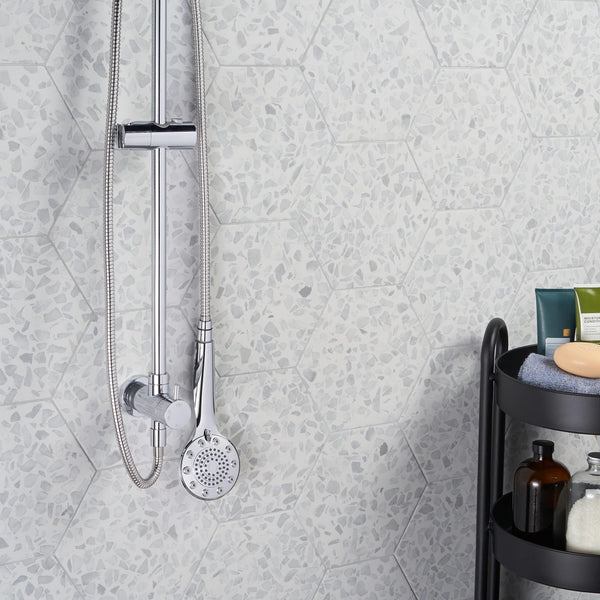 A modern shower with a chrome-finished detachable showerhead is mounted on a wall of Riazza 9
