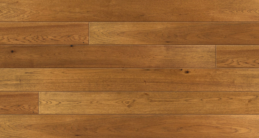 A close-up of Saloon 7 1/2" Hickory & Maple Hardwood flooring shows horizontal wooden planks with a natural grain pattern, various brown shades, and subtle knots for an authentic look.