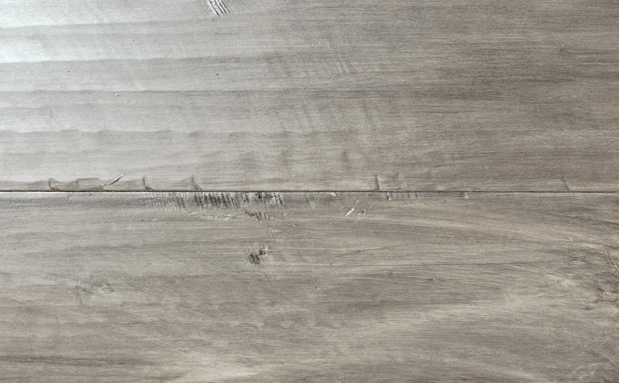 Close-up of two horizontal, light gray planks with visible grain and subtle texture—including small scratches—reminiscent of a hand honed floor in the Saloon 7 1/2" Hickory & Maple Hardwood collection.