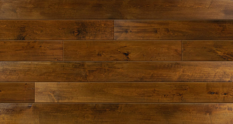 A close-up view of Saloon 7 1/2" Hickory & Maple Hardwood shows wide planks in varied brown shades, with visible grain, knots, and subtle imperfections from the Saloon Series for a rustic look.
