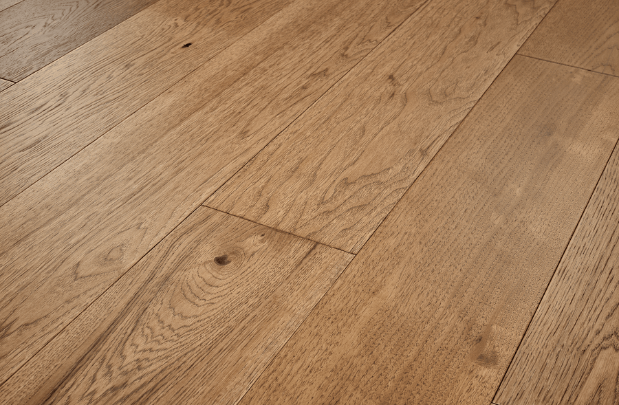 Close-up of Fairmount Hickory 7 1/2" Hardwood floorboards, highlighting the natural grain, warm brown tones, and richly textured hand-stained hickory surface.