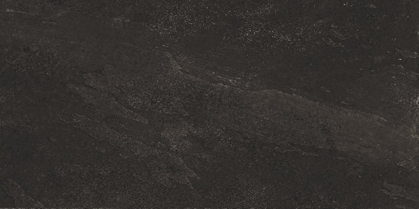 Shyft 12x24 Rectified Porcelain Tile features a dark, textured surface with subtle gray and black variations, rough patches, and natural mineral patterns—capturing the elegant look of Brazilian slate in durable porcelain.