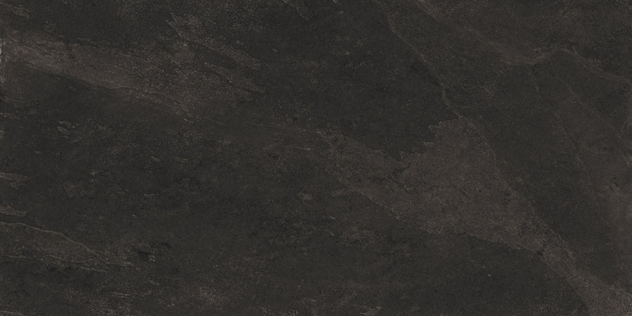 Shyft 24x48 Rectified Porcelain Tile features a dark, textured surface with subtle black and gray variations, natural patterns, and faint streaks that mimic Brazilian slate for a rugged, slate-like look.