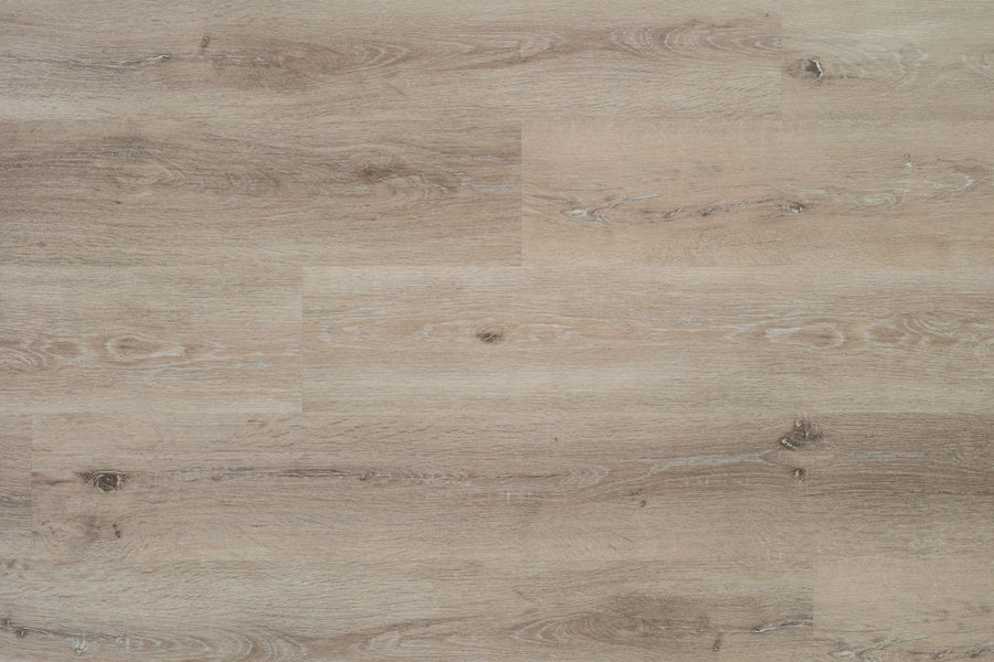 Hydro Vinyl II 7" Vinyl Plank features light brown, waterproof SPC flooring with natural wood grain and knot patterns. The planks install side by side for a seamless, smooth surface that mimics real hardwood in look and texture.