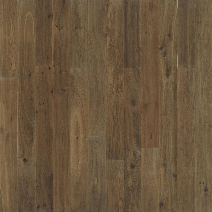 A close-up of Baldwin Hills 6" Hardwood flooring shows medium brown planks with natural wood grain patterns and subtle knots, creating a rustic look.