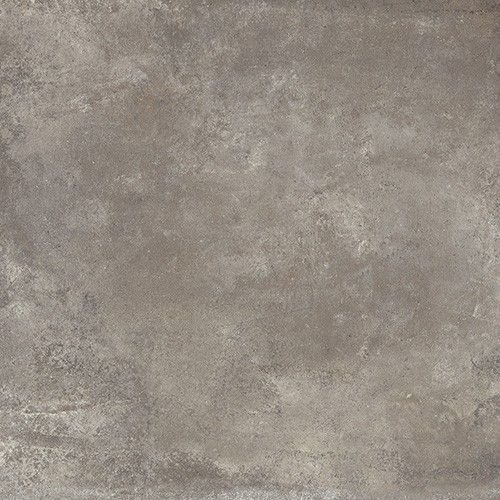 A close-up of the Chateau 18x18 Porcelain Tile shows its textured grey surface with subtle color variations and rough patches, creating a weathered, industrial look.