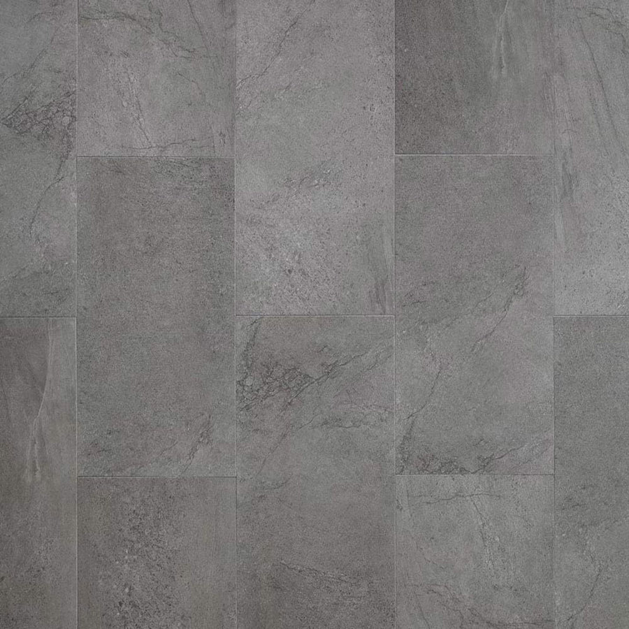 Meridian Adura® Rigid 12x24 Vinyl Tile features gray stone visuals with subtle shade and texture variations, arranged in a staggered pattern. It mimics weathered concrete with fine lines and veining for a modern, slate-like look.