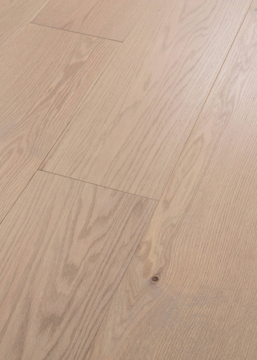 Close-up of splash-proof Vogue 9 1/4" Hickory & Red Oak Hardwood floors featuring natural grain, subtle texture, and tight seams between the light-colored planks.