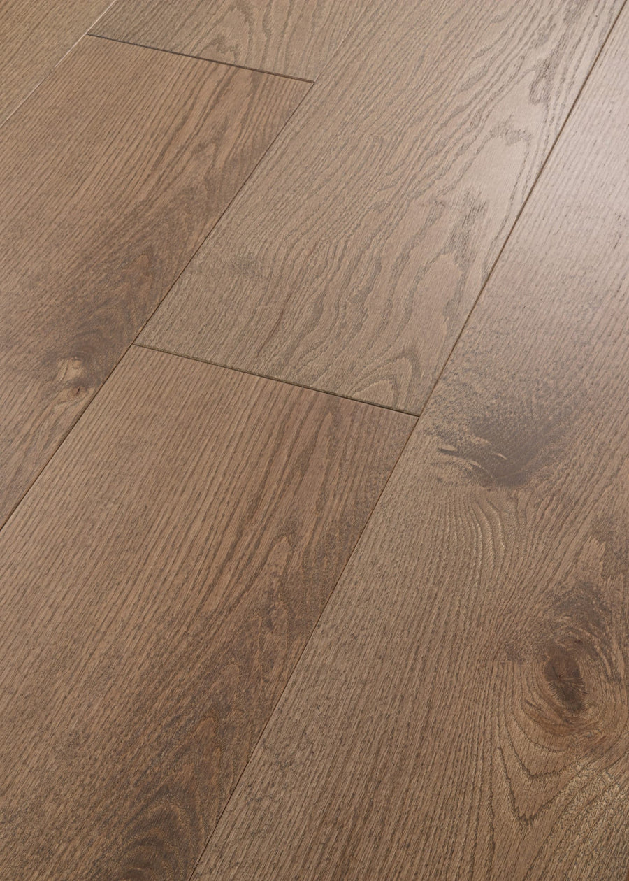 Close-up of Vogue 9 1/4" Hickory & Red Oak Hardwood floors featuring a brown, splash-proof finish with natural wood grain, visible knots, and a staggered installation pattern.