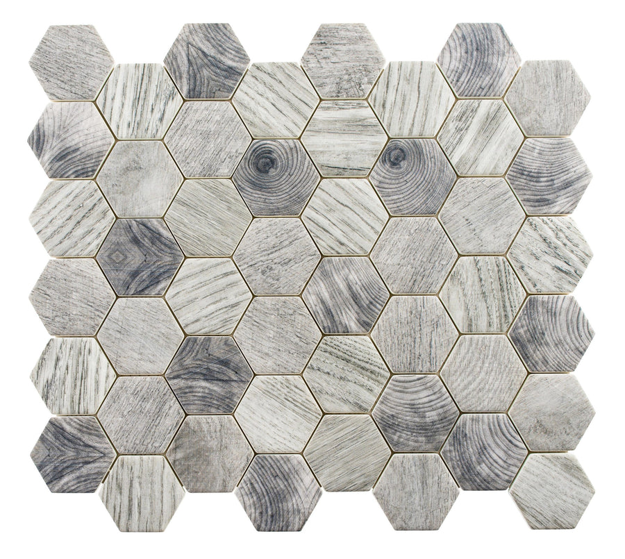 The Woodland Hexagon Mosaic Glass Tile features a wood grain pattern in shades of gray and beige, forming a striking honeycomb mosaic against a crisp white background.