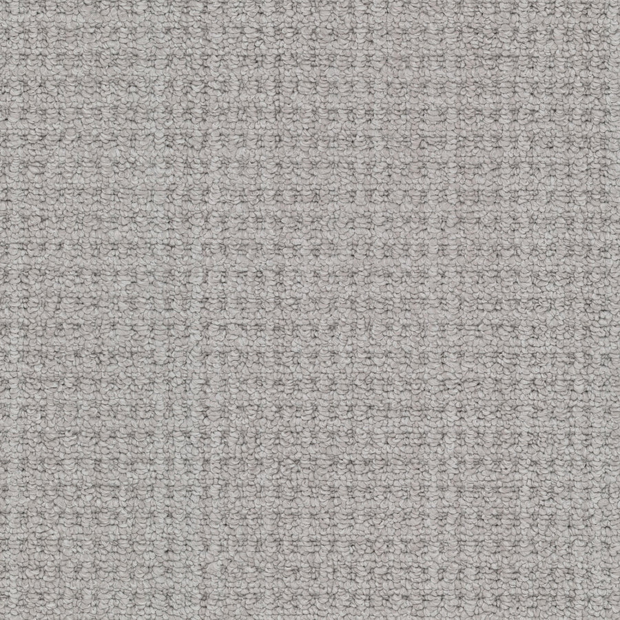 Close-up of Winslow Berber Carpet in light gray, highlighting its textured woven surface with a subtle grid pattern and slightly raised threads that create natural shading variations.